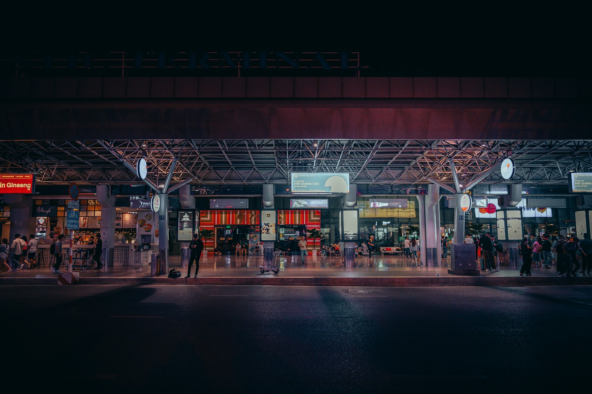 a group of people standing outside of a building at night